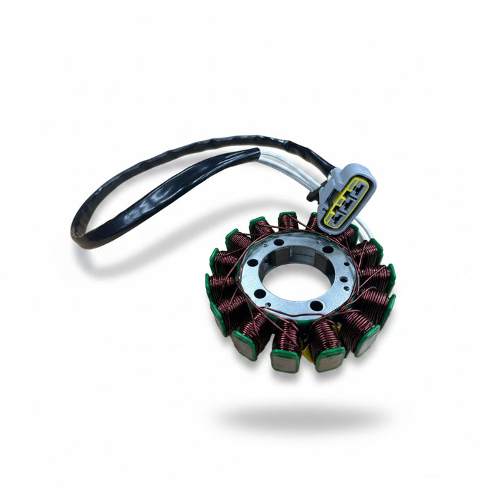 A stator coil for a motorcycle or scooter, featuring copper wire wrapped around green plastic cores, a central metal hub, and a black cable with a gray electrical connector, shown on a light wood background.
