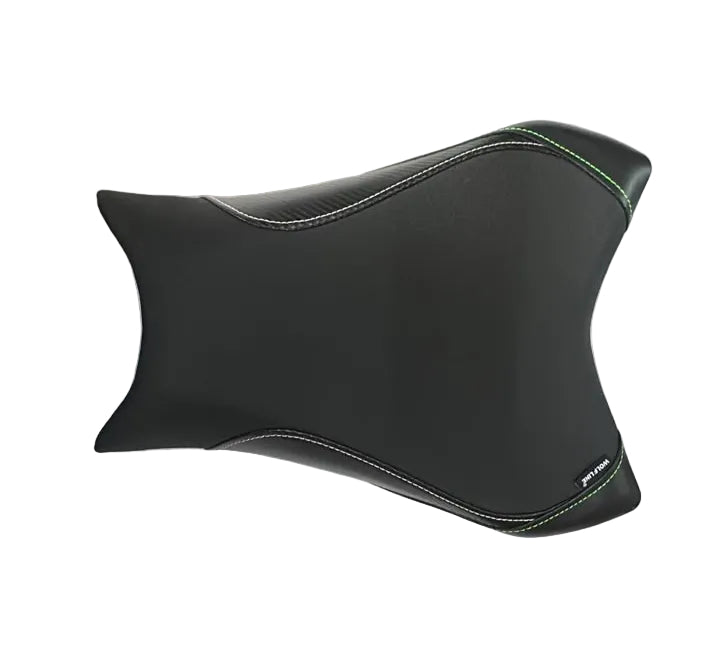 A black motorcycle or scooter seat cover with white contrast stitching and a small green accent line, laid flat on a white sheet in a warehouse setting with cardboard boxes visible in the background.