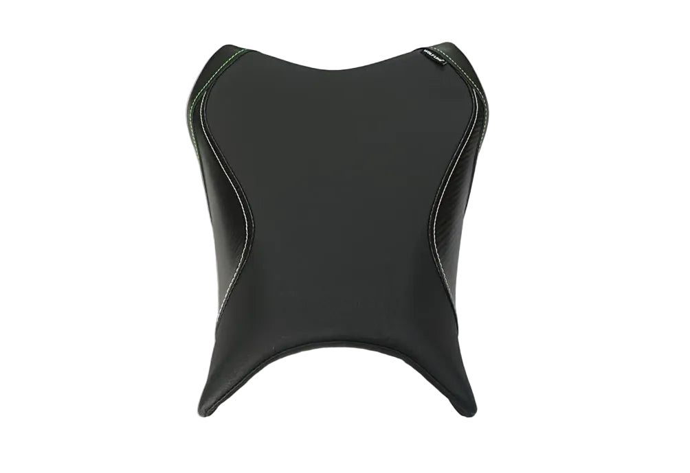 A black motorcycle or scooter seat cover with white contrast stitching, laid flat on a white protective sheet inside a warehouse or storage area with cardboard boxes visible in the background.