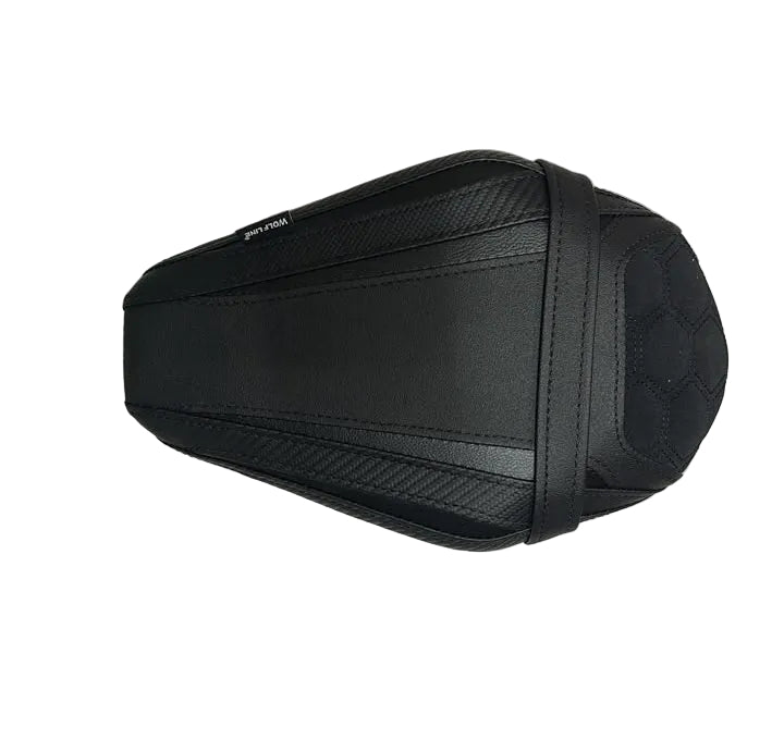 A black motorcycle or scooter seat cover cushion, shown from a top-down view on a white protective paper sheet with cardboard boxes visible at the bottom.