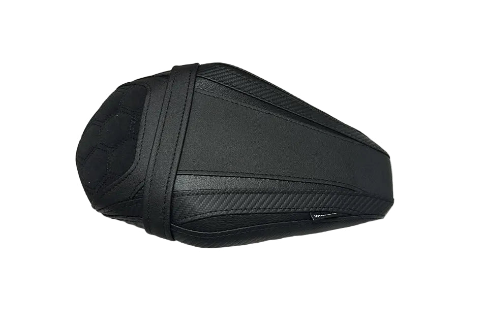 A black motorcycle or scooter seat cover with textured stitching and carbon-fiber-style patterns, resting on a white protective sheet.