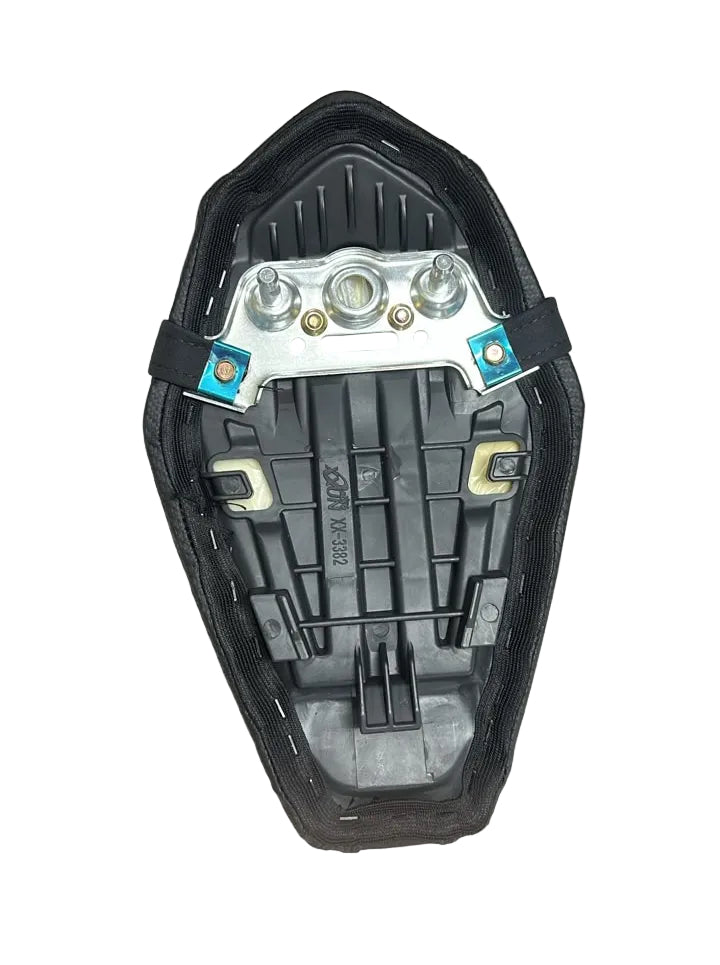 A black motorcycle or scooter seat shell with a silver metal mounting bracket and blue-colored fasteners, displayed on a white fabric surface.
