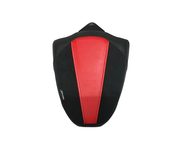A motorcycle or scooter seat cover with a black and red design, placed on a white fabric sheet over cardboard boxes.