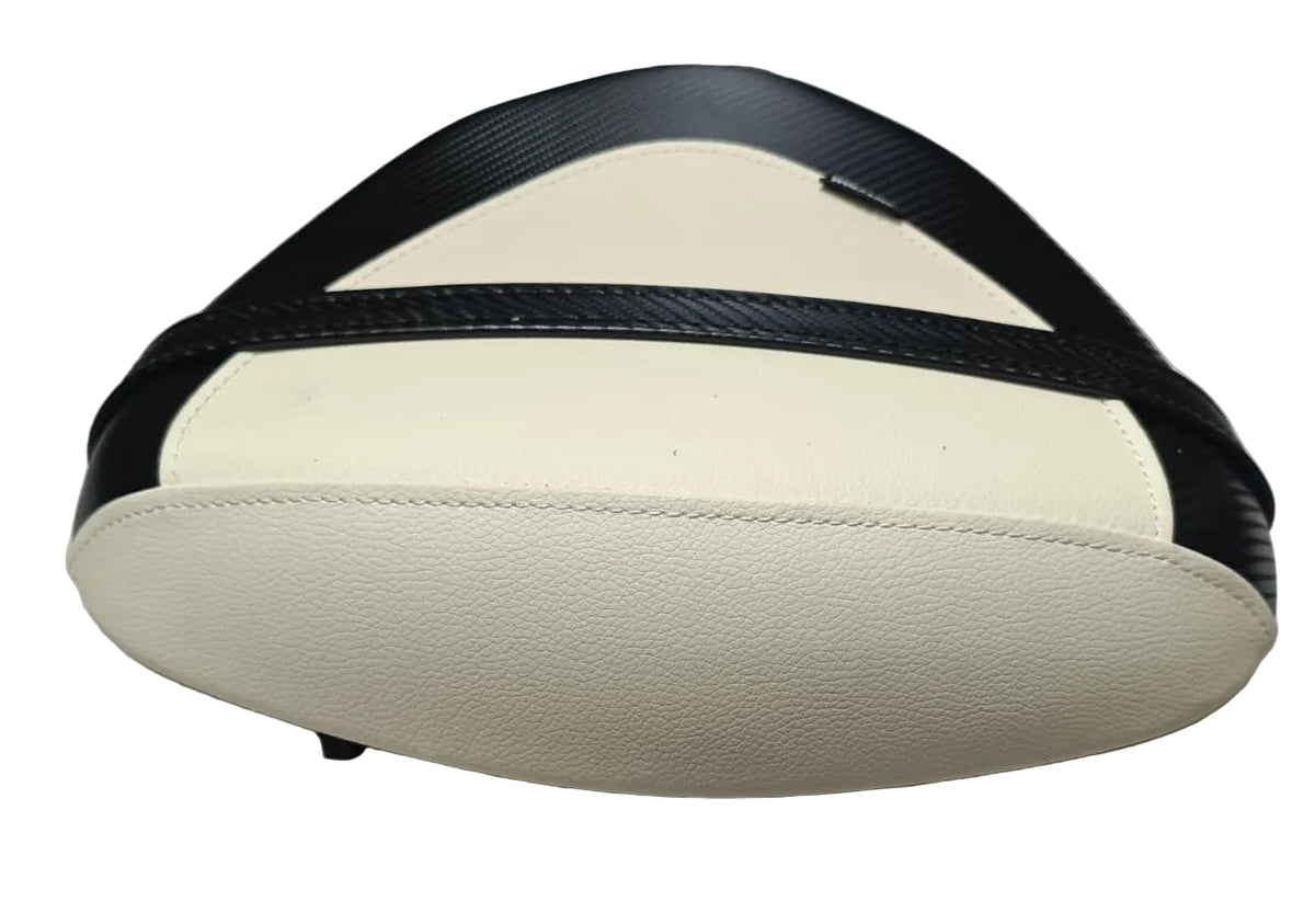 A motorcycle or scooter rear passenger seat cushion with cream-colored textured upholstery and black trim, resting on a white fabric surface.