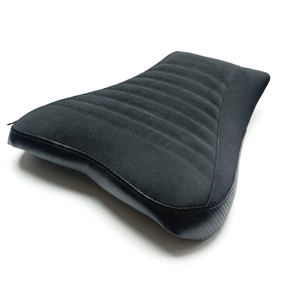 A black motorcycle or bicycle saddle with a quilted top surface and ribbed lower side, shown on a plain white background.