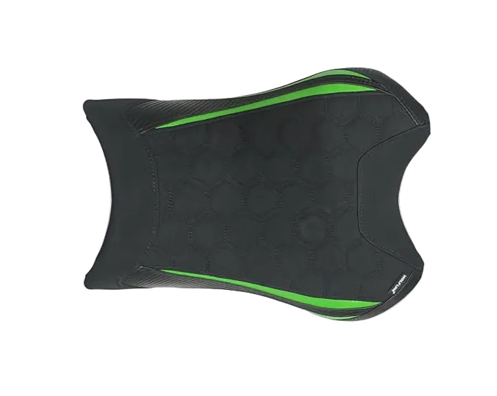 A black motorcycle or scooter seat pad with green accent lines, laid flat on a white cloth over cardboard boxes.