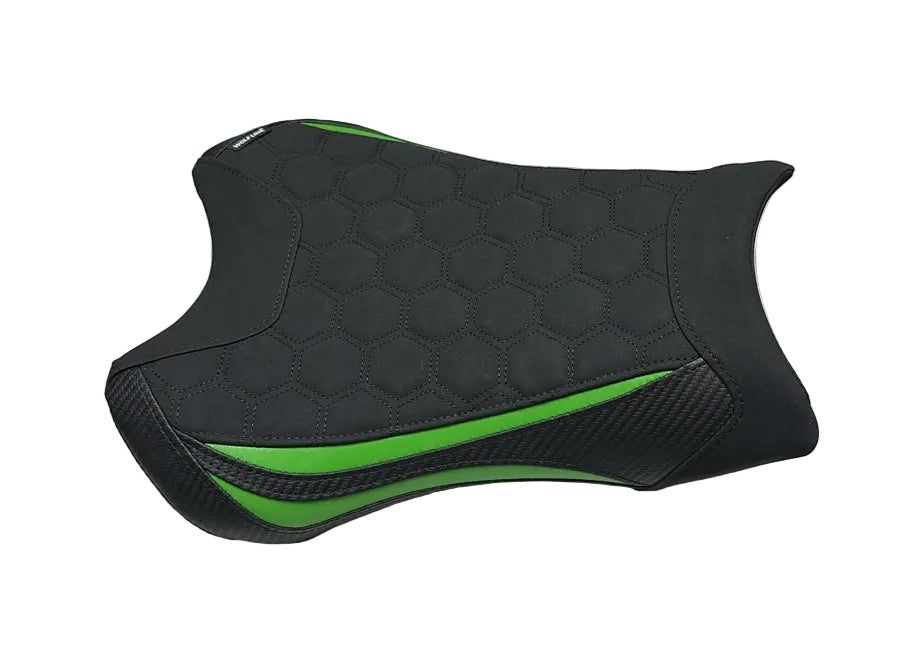 A black motorcycle or scooter seat cover with green accents, displayed on a white plastic sheet in a warehouse setting.