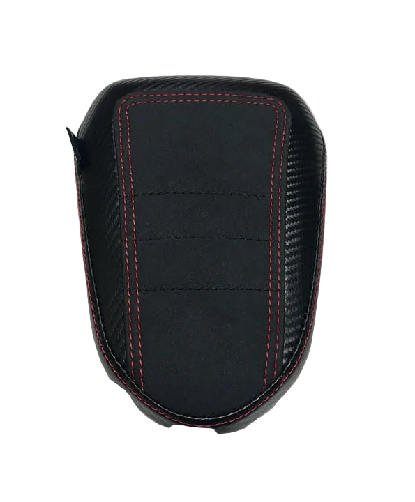 A black motorcycle or scooter seat cover with red contrast stitching, displayed on a wrinkled white sheet.
